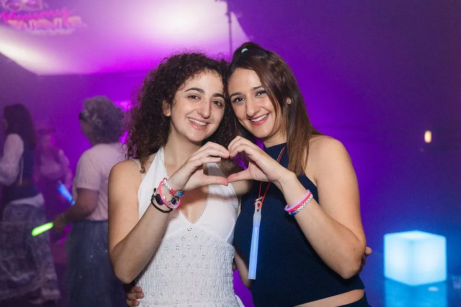 Two women making a heart together
