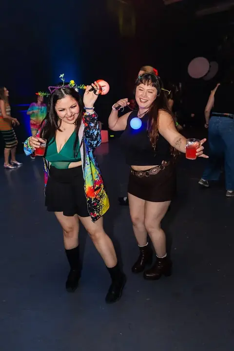 Two women dancing with drinks