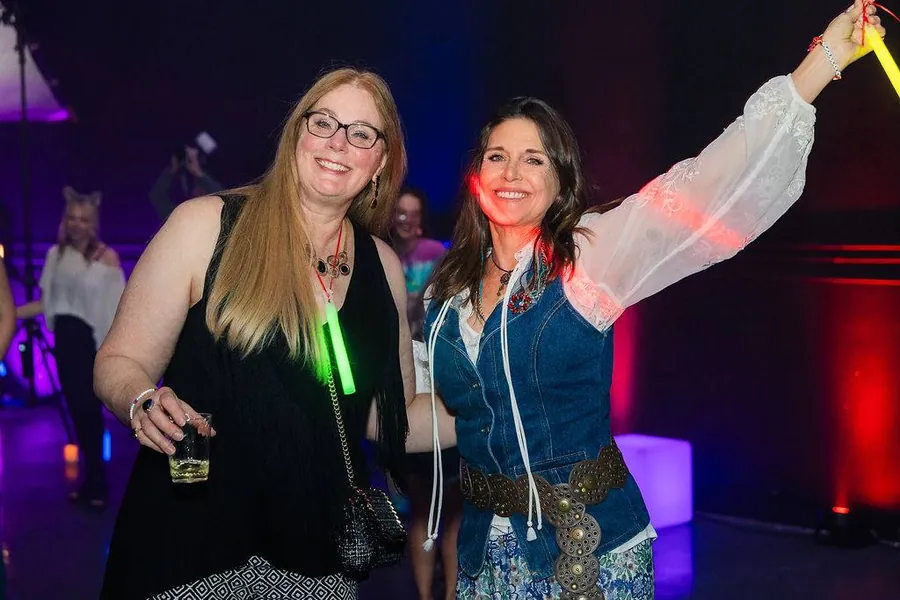 Two women with glow sticks smiling
